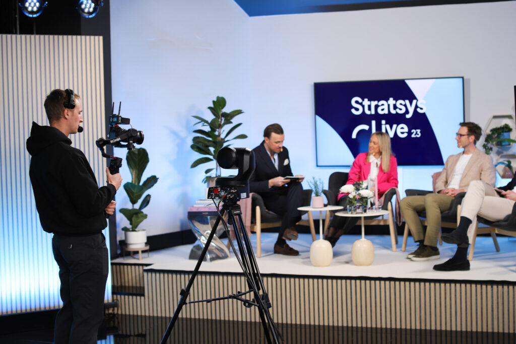 Image of cameraman filming panel discussion during digital event