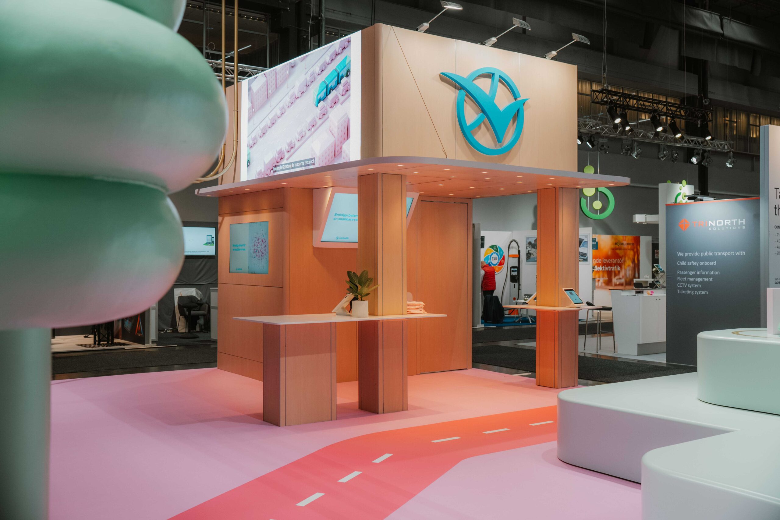 Västtrafiks träpaviljong med varumärkeslogotyp och skärmar