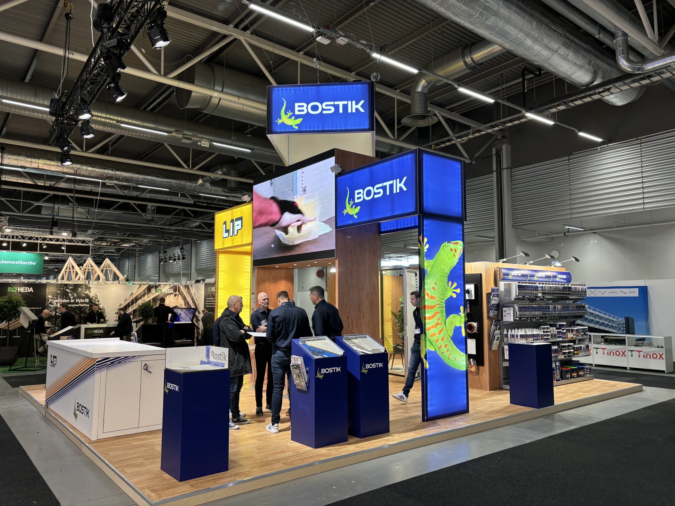 En delad monter för Bostik och LIP med träprintade väggar, stora takskyltar med lysande branding och demoytor. Monterdesignen är funktionell med produktpodier, informationsytor och mötesrum med glasväggar. LED-skärmar visar rörligt innehåll för ökad aktivering