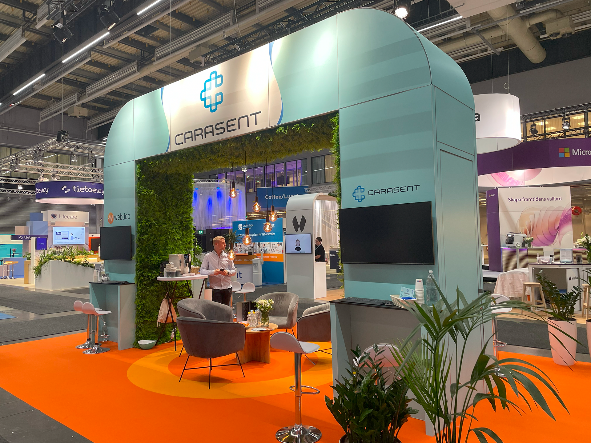 Carasents mässmonter med gröna växter och hållbar design.