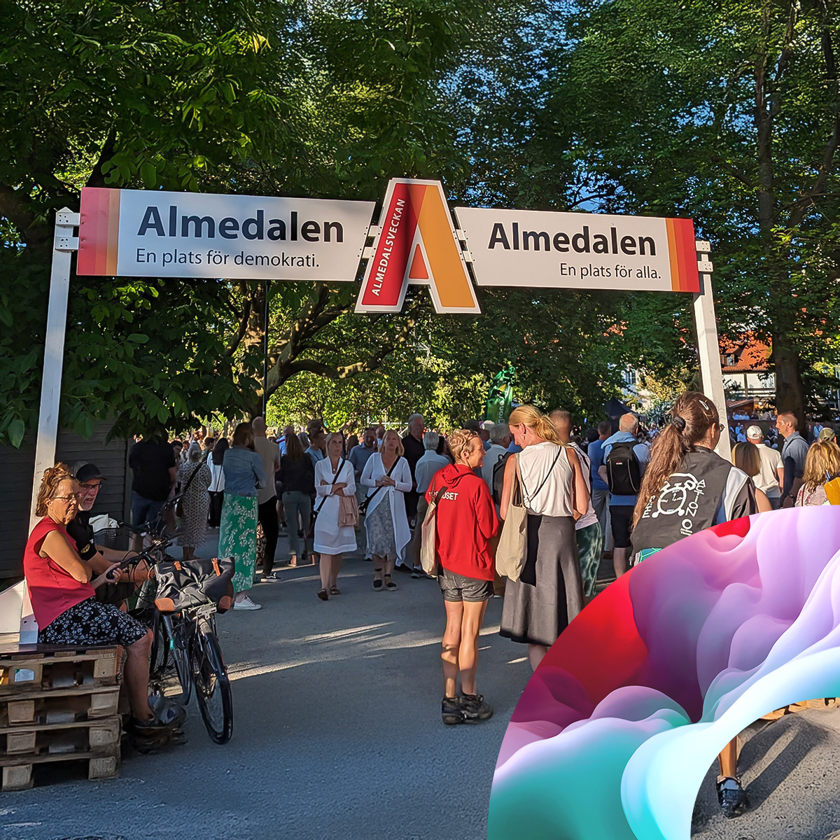 A crowd of people walks under a large “Almedalen” entrance sign at an outdoor event surrounded by trees. Some people stand, talk, or cycle. In the foreground is a colorful abstract shape.